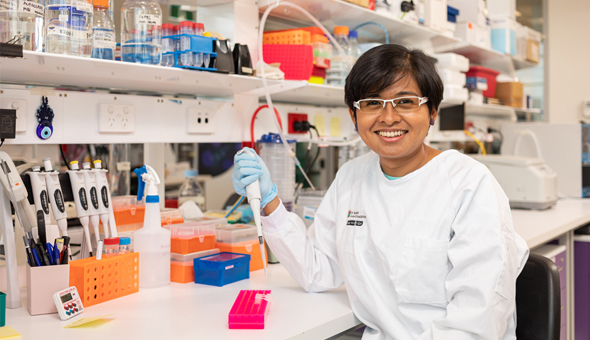 Female researcher working in lab smiling at camera
