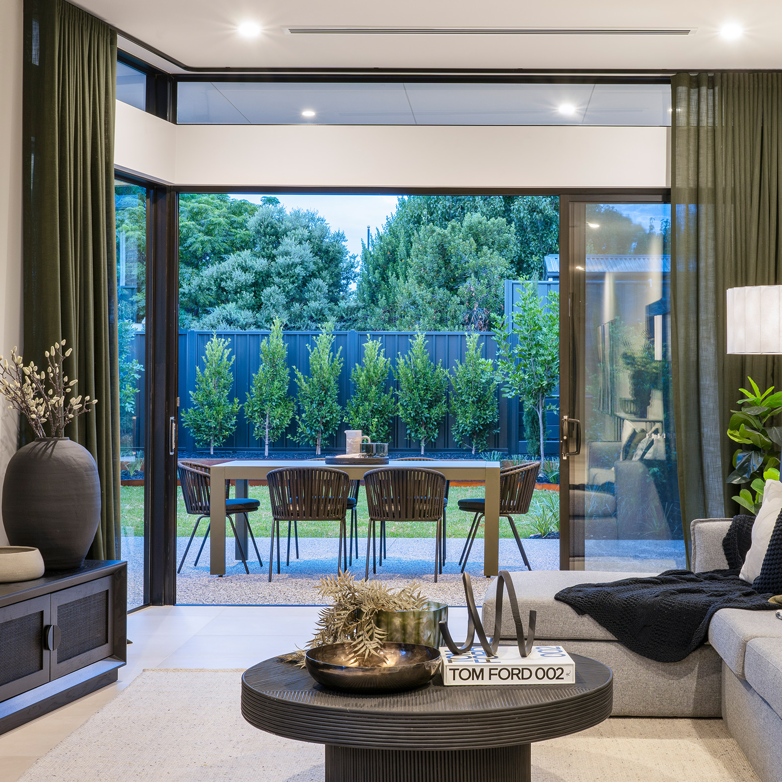 Living area with back sliding doors open to the backyard alfresco area
