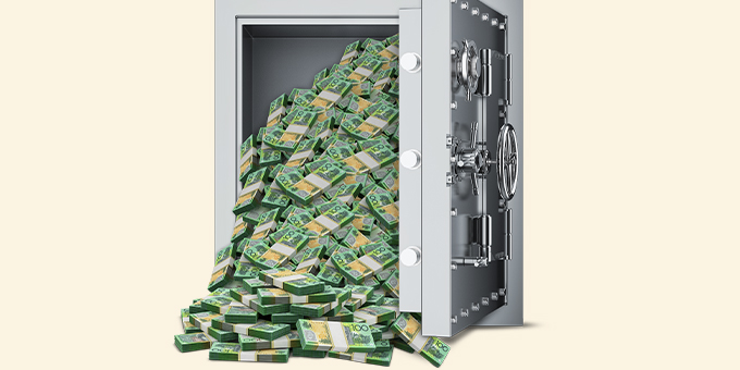 Silver vault with cash falling out on cream background