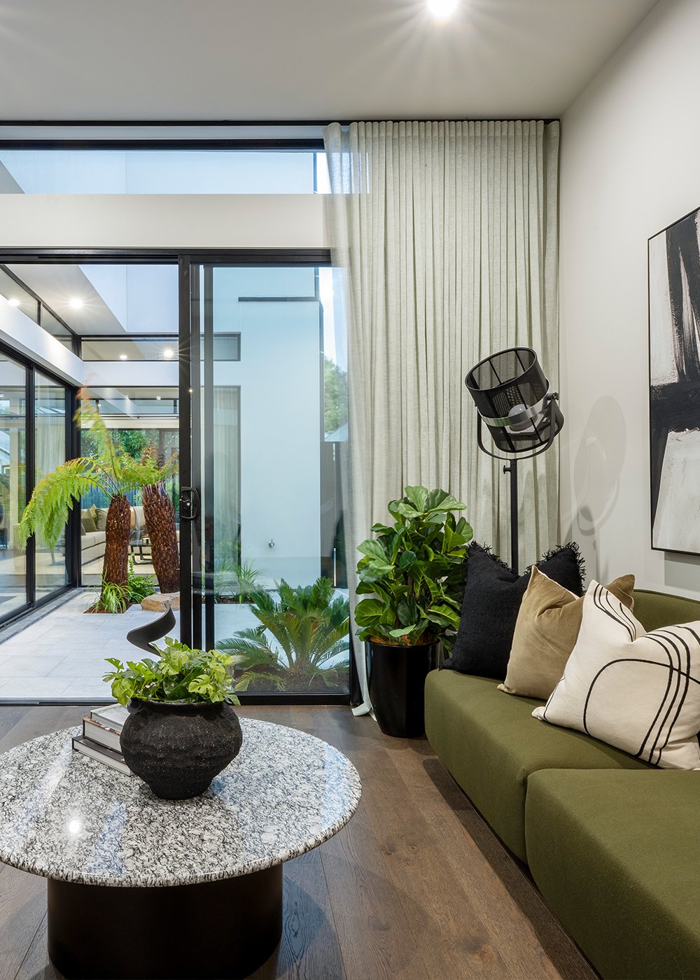 Green and white sitting room with sliding doors to paved courtyard